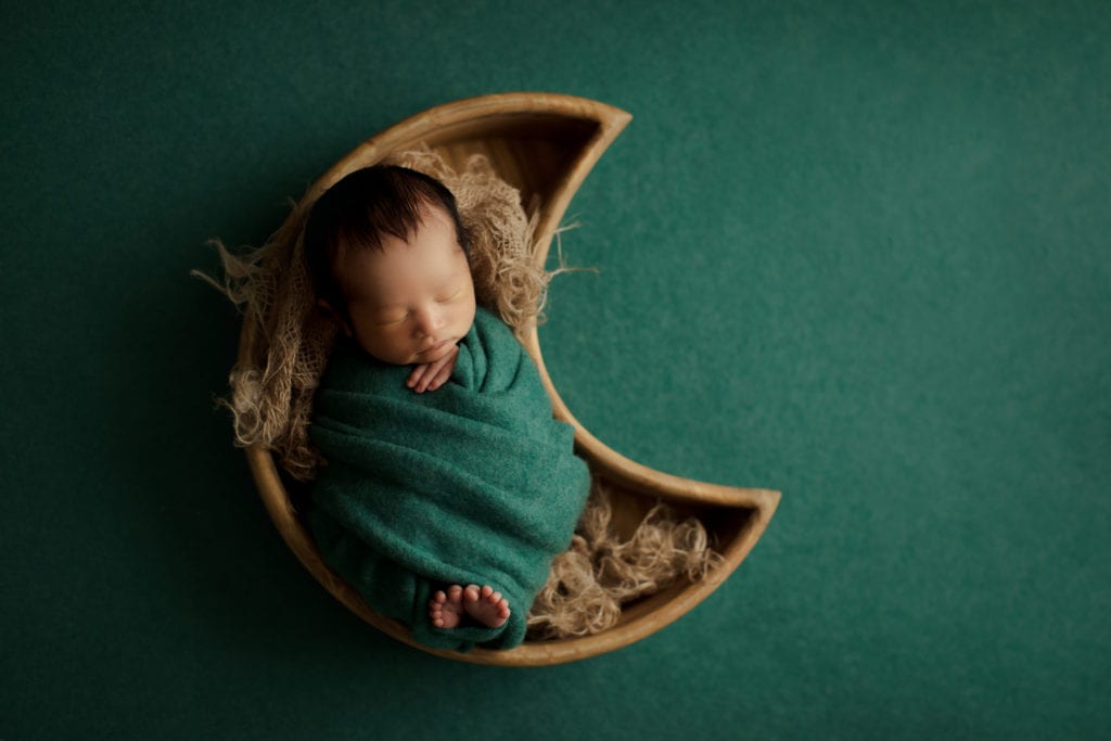 baby boy in moon shaped basket 