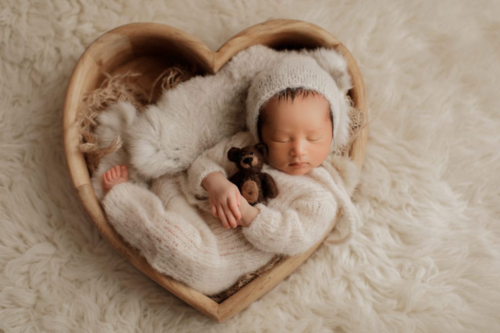 newborn baby boy in heart shaped bowl