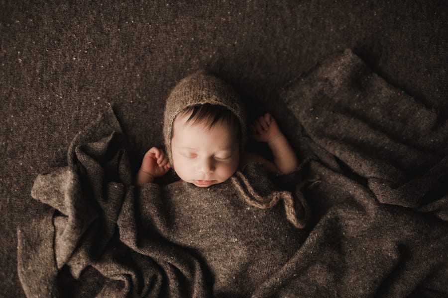 sweet baby boy under brown blanket wrap