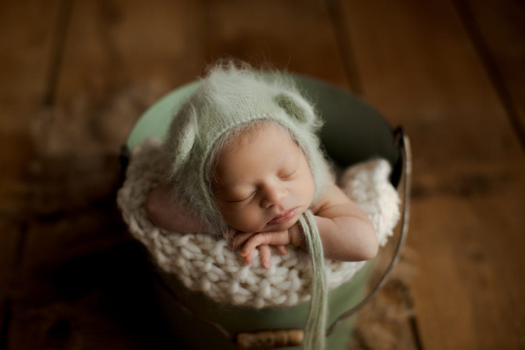 sweet newborn in green bucket