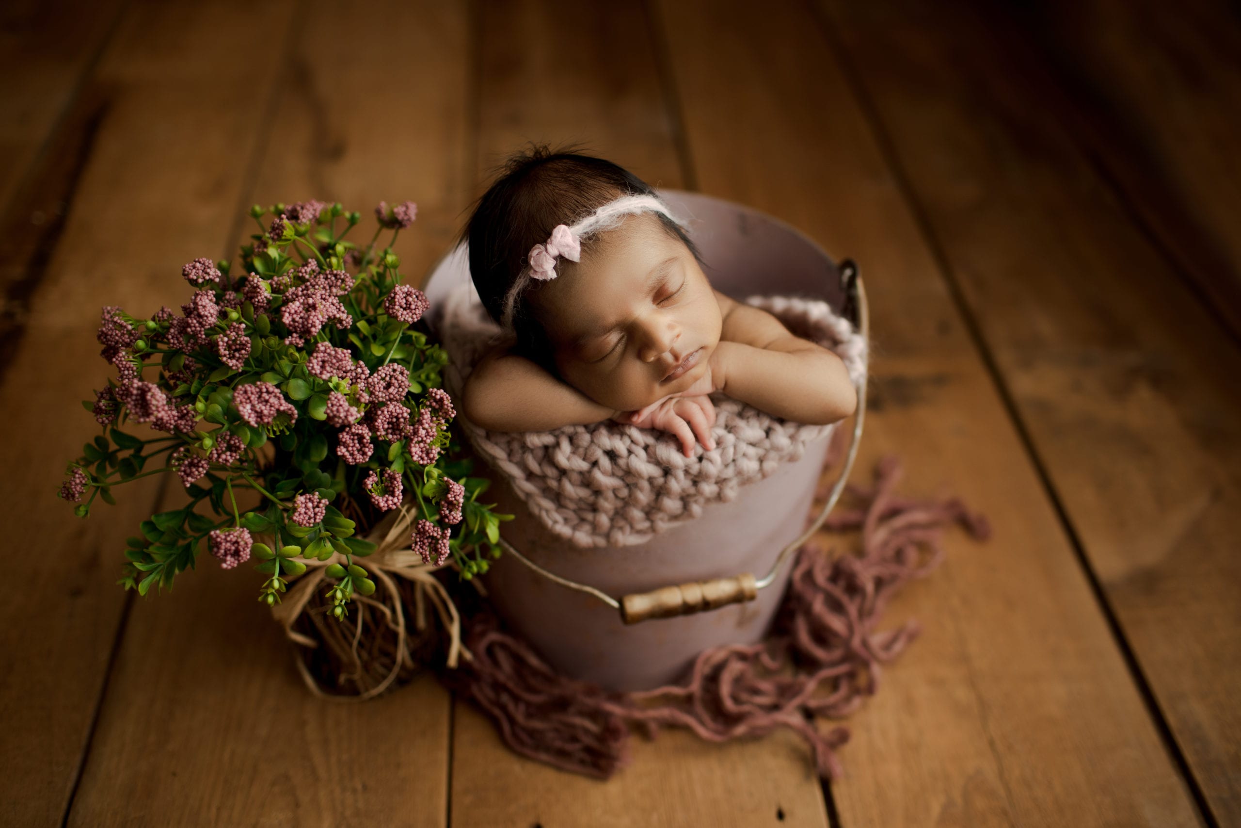 baby girl sound asleep in bucket prop
