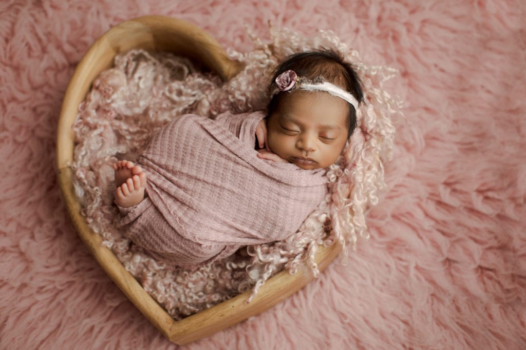 newborn baby in heart basket