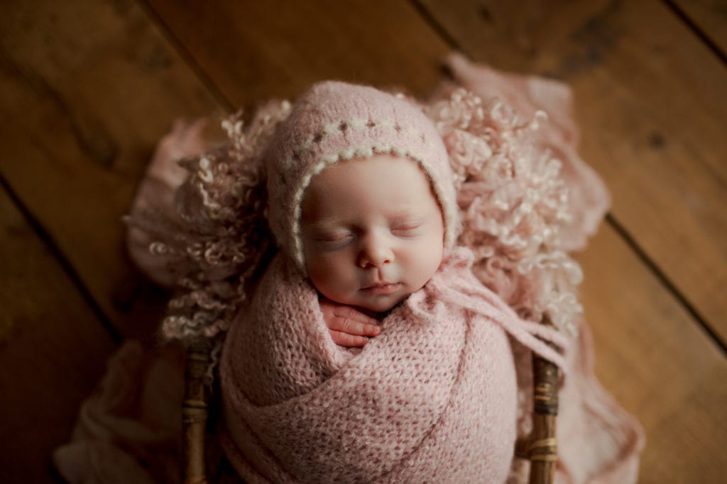 newborn baby girl wrapped in pink