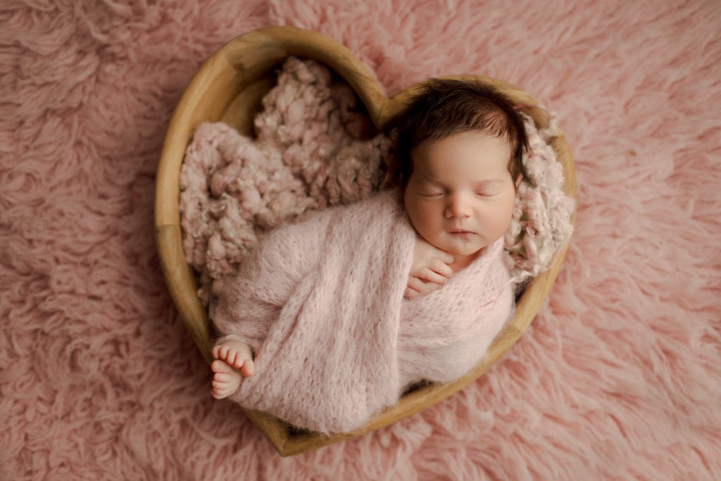 newborn girl in heart bowl