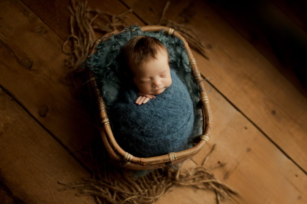 newborn boy in blues in a basket