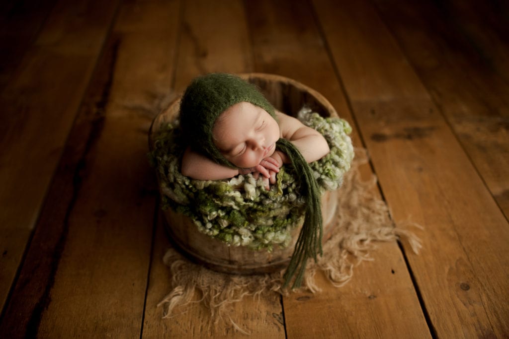 baby boy in greens in a basket