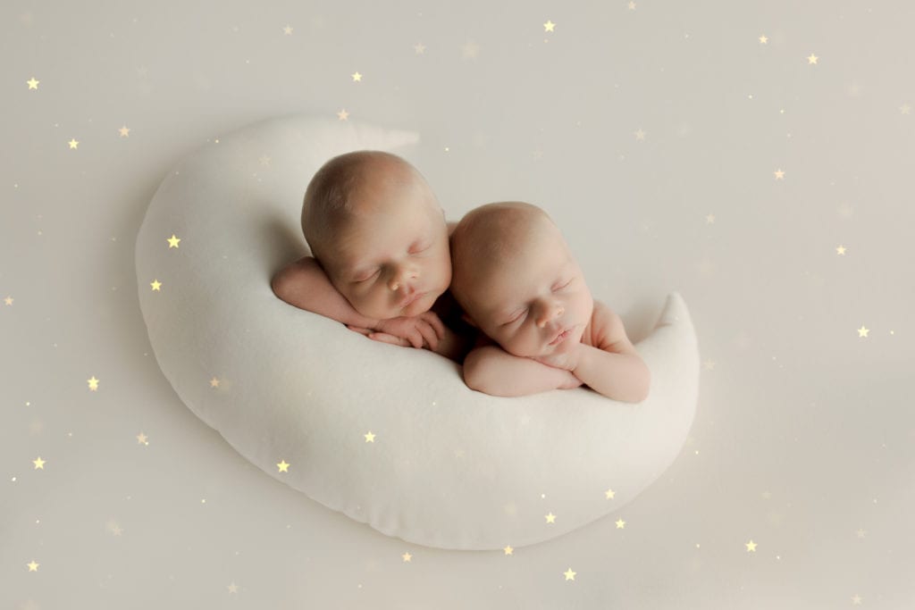 twin newborn brothers on moon pillow