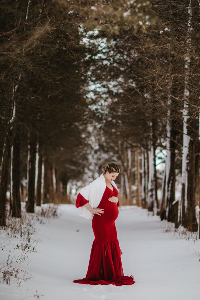 Chicago maternity photography, woman in red gown standing in snow