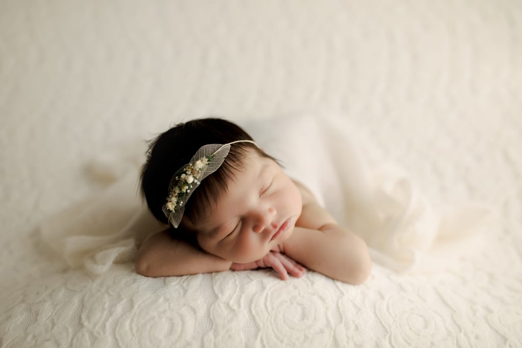 best newborn photographers near me, Chicago, baby girl asleep on white backdrop