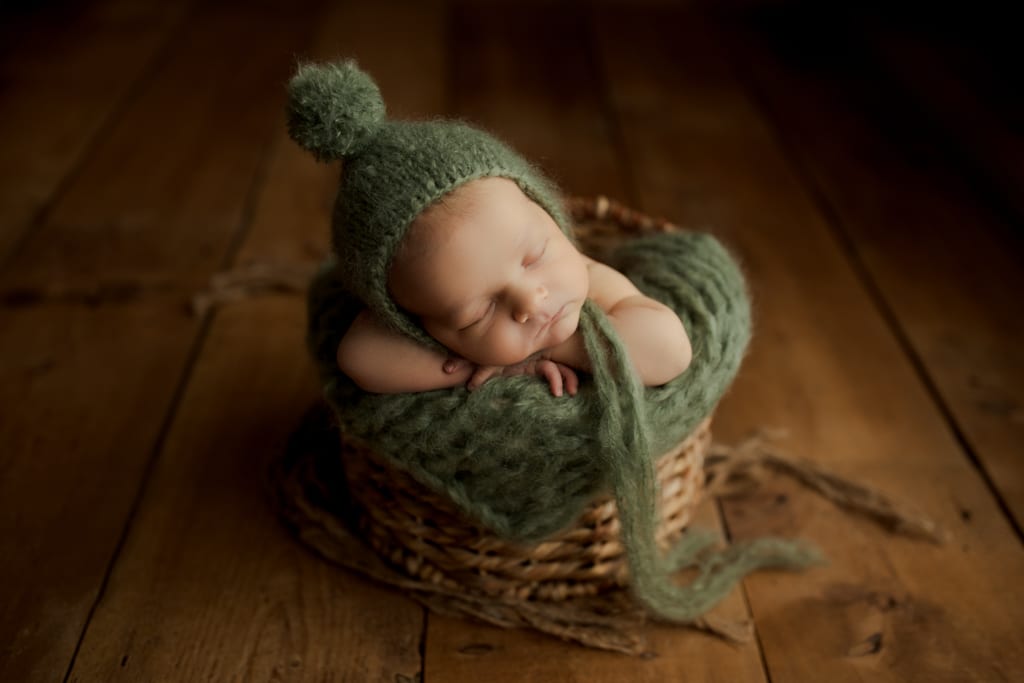 Chicago newborn photos, baby in green hat sleeping in basket