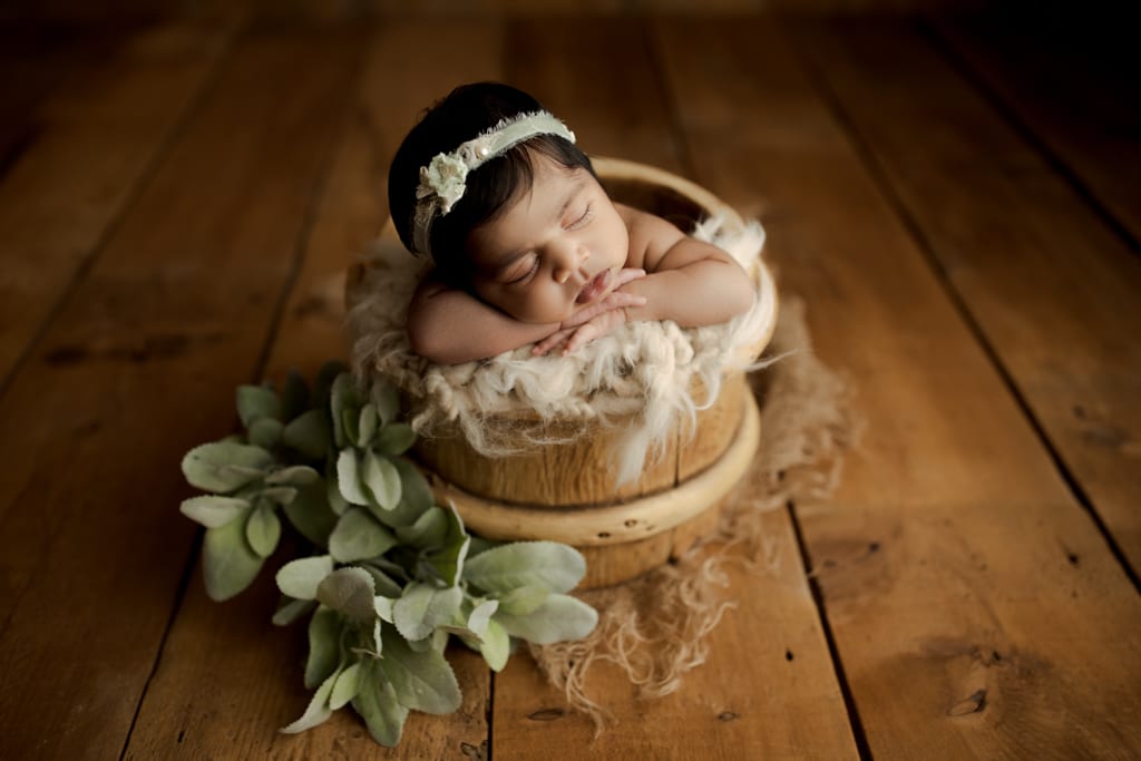 Chicago newborn photoshoot, baby girl in bucket with greenery