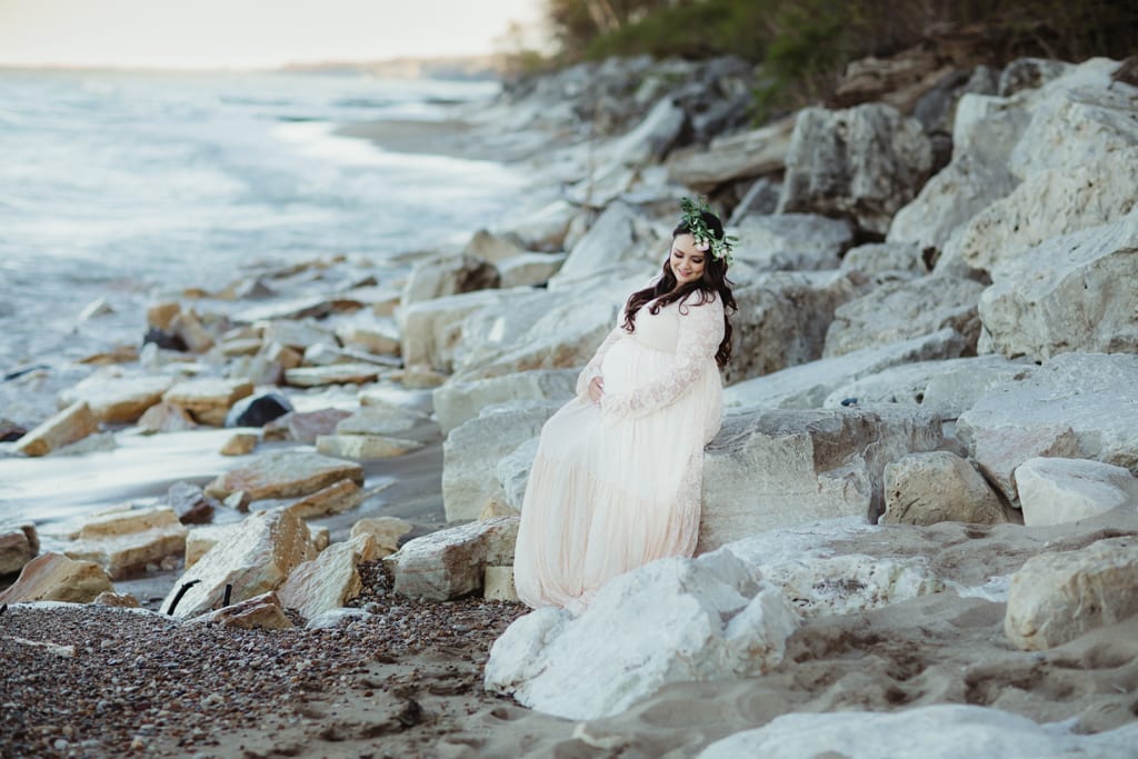 best chicago maternity photographer, woman in white maternity gown on rocky beach