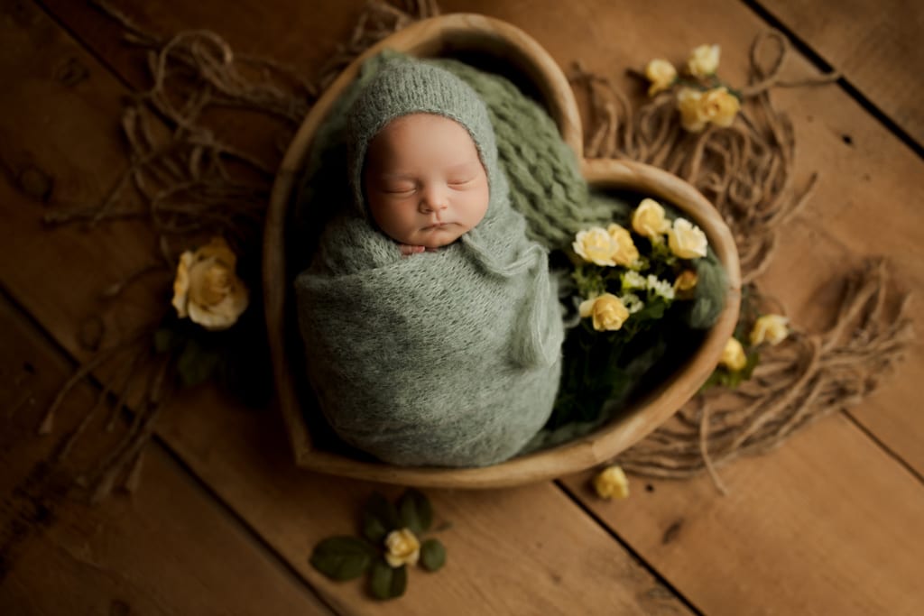 Chicago newborn studio, swaddled baby in wooden bowl with yellow roses