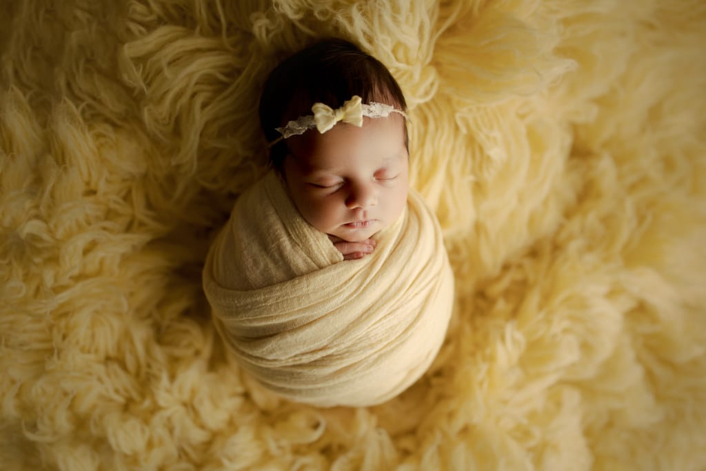 Chicago newborn photographer, baby girl in yellow swaddle with headband