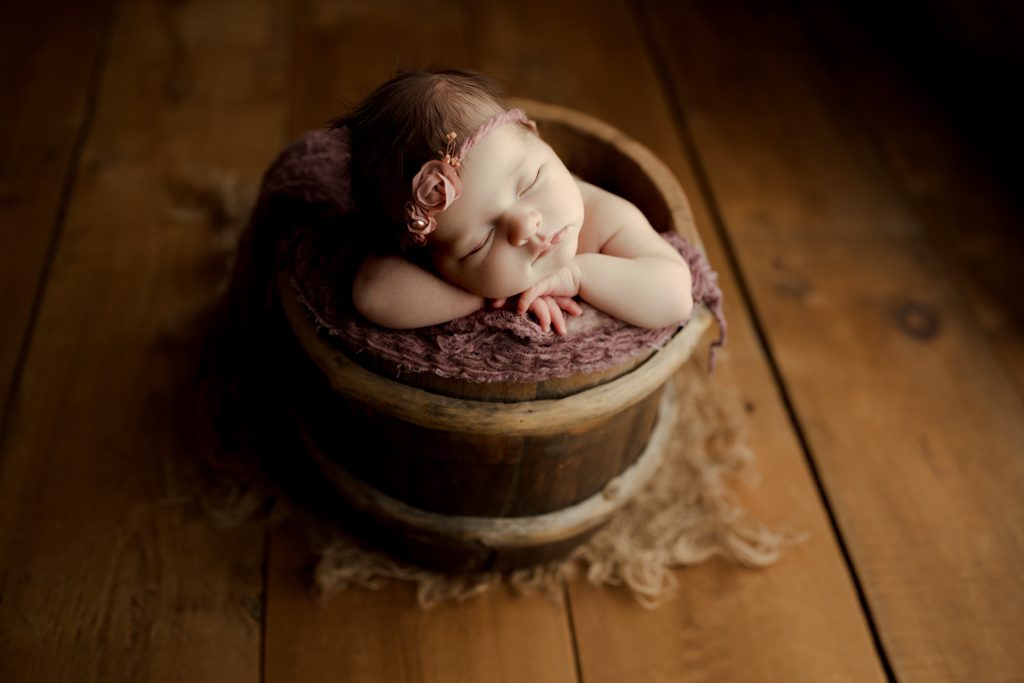 Long Grove baby photographer, newborn girl in bucket with flower headband