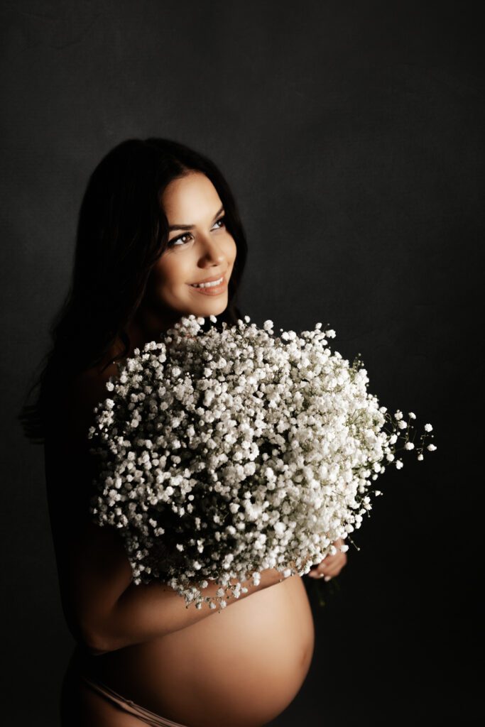 Pregnant woman holding bouquet of baby's breath