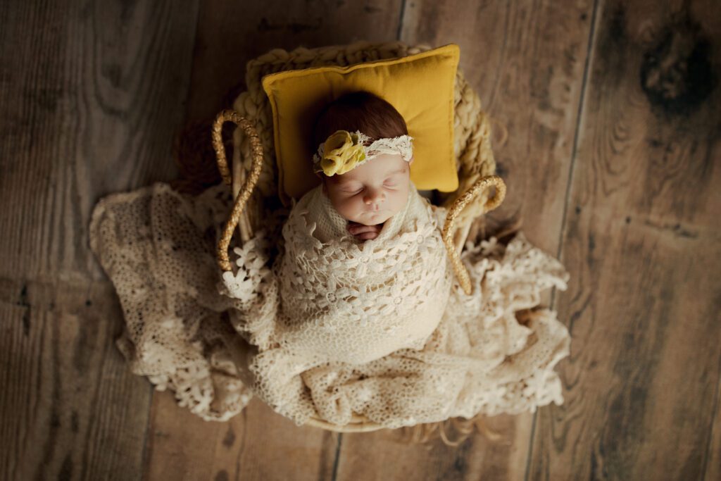 Highland Park newborn photographer. Baby girl asleep in basket with yellow pillow.