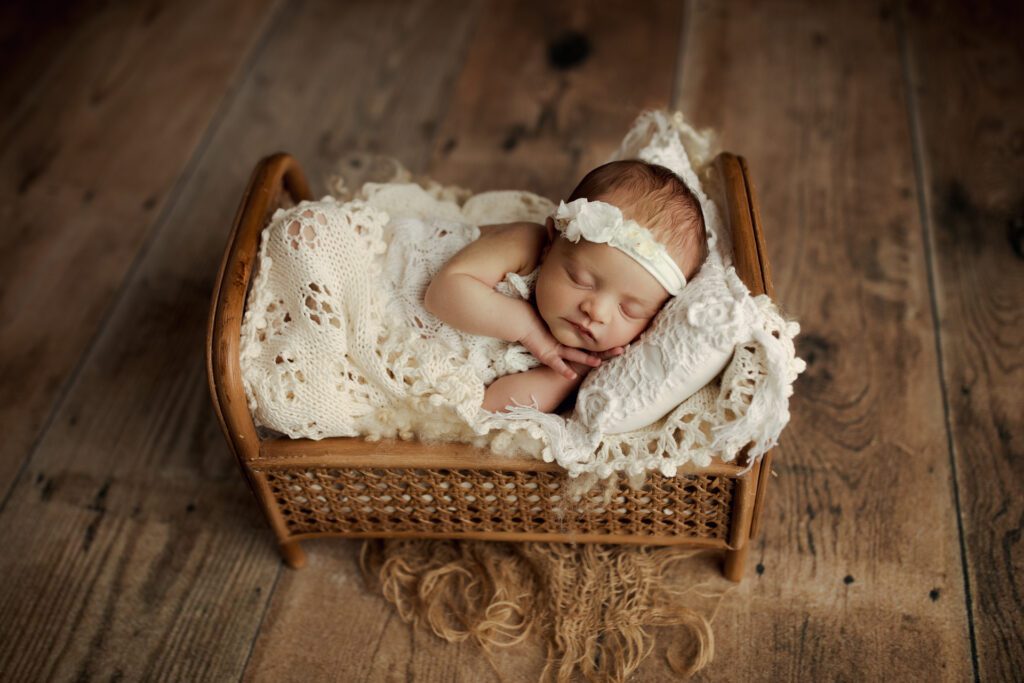 Sleeping infant in miniature crib in photography studio near Highland Park, Illinois