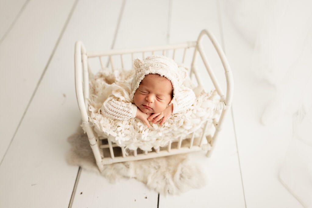 Baby asleep in mini bed in Chicago newborn photography studio