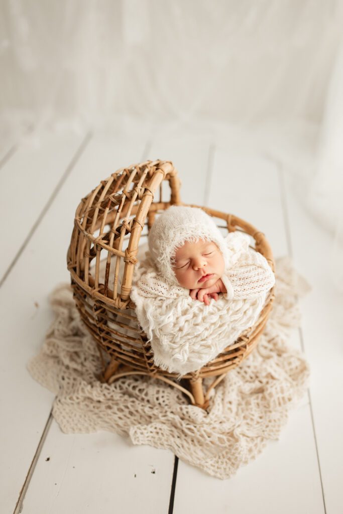 New baby in miniature wicker crib