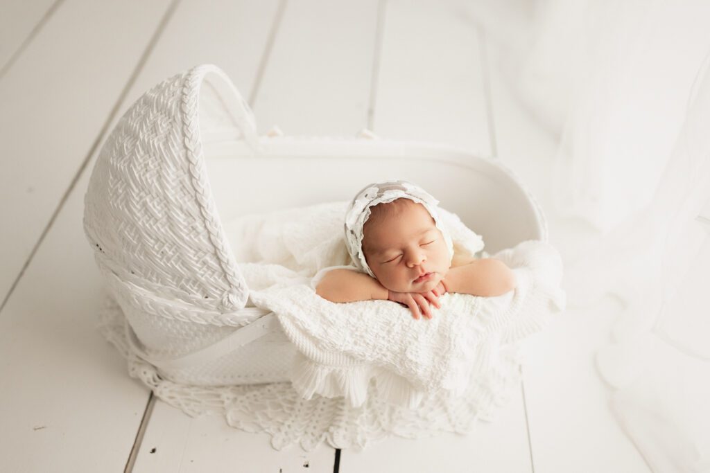 Infant in white bassinet