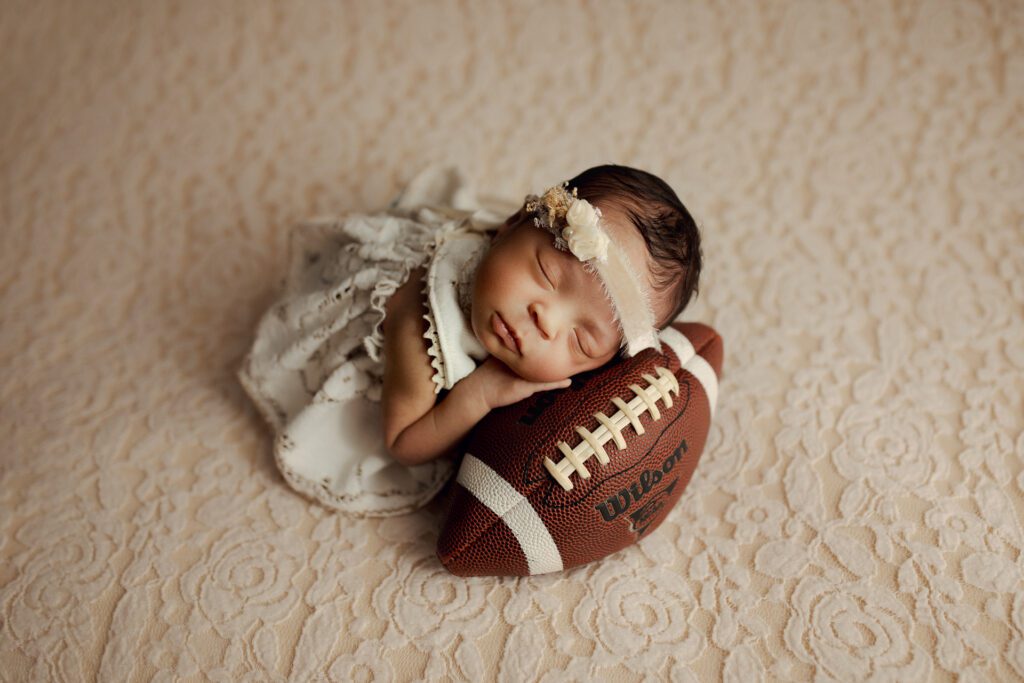 Baby girl asleep on football