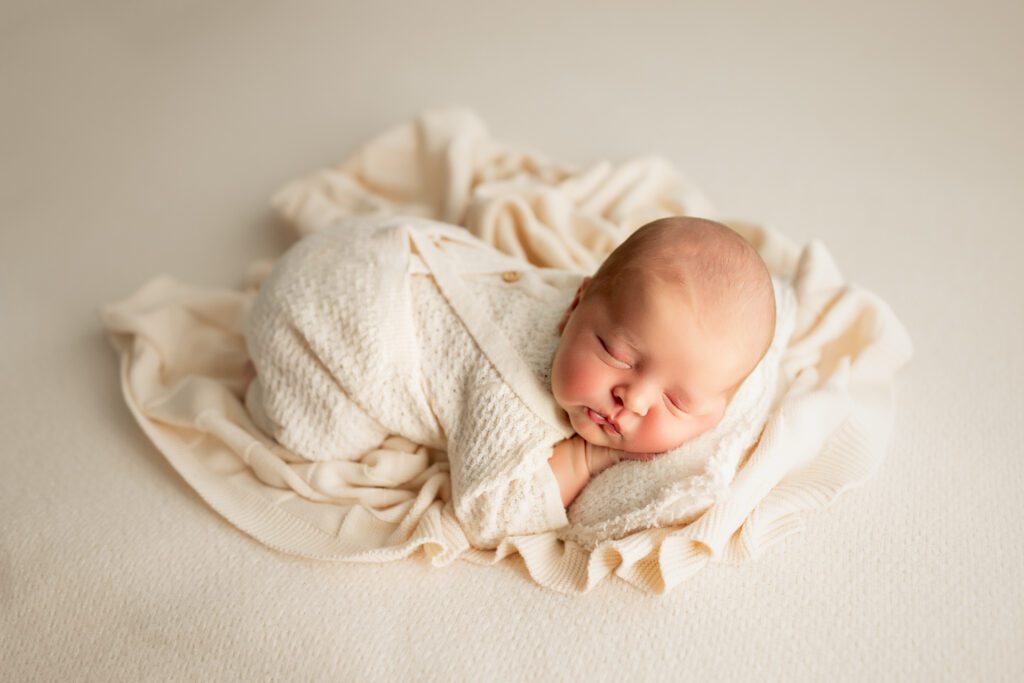 Baby boy asleep on white blanket, captured by Palatine Illinois newborn photographer