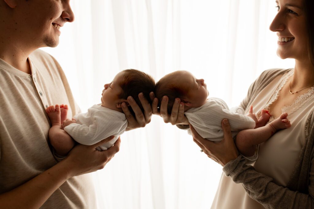 Parents holding newborn twins in Illinois photography studio
