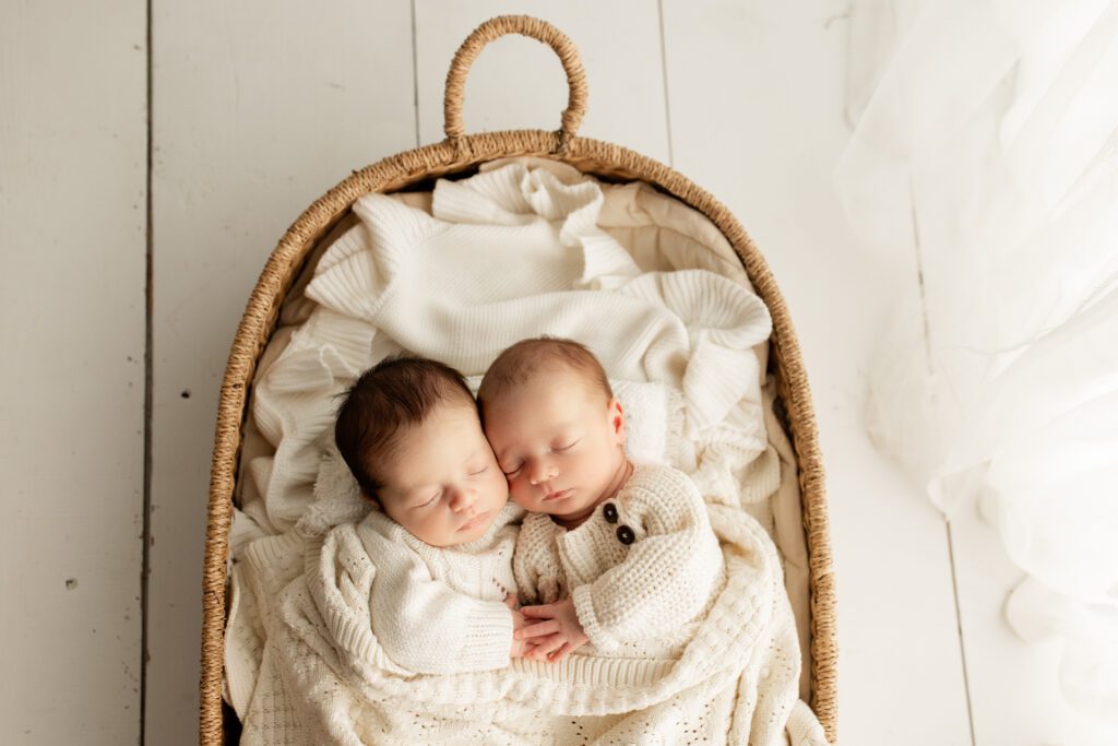 Chicago twin babies snuggling together in bassinet