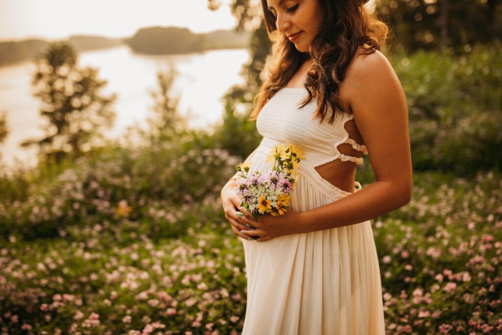 Pregnant woman standing in a field of wildflowers in Illinois