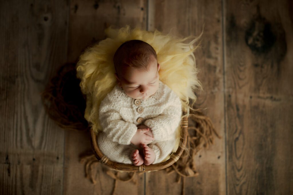 Baby boy asleep in wicker basket in photo studio near Evanston, Illinois