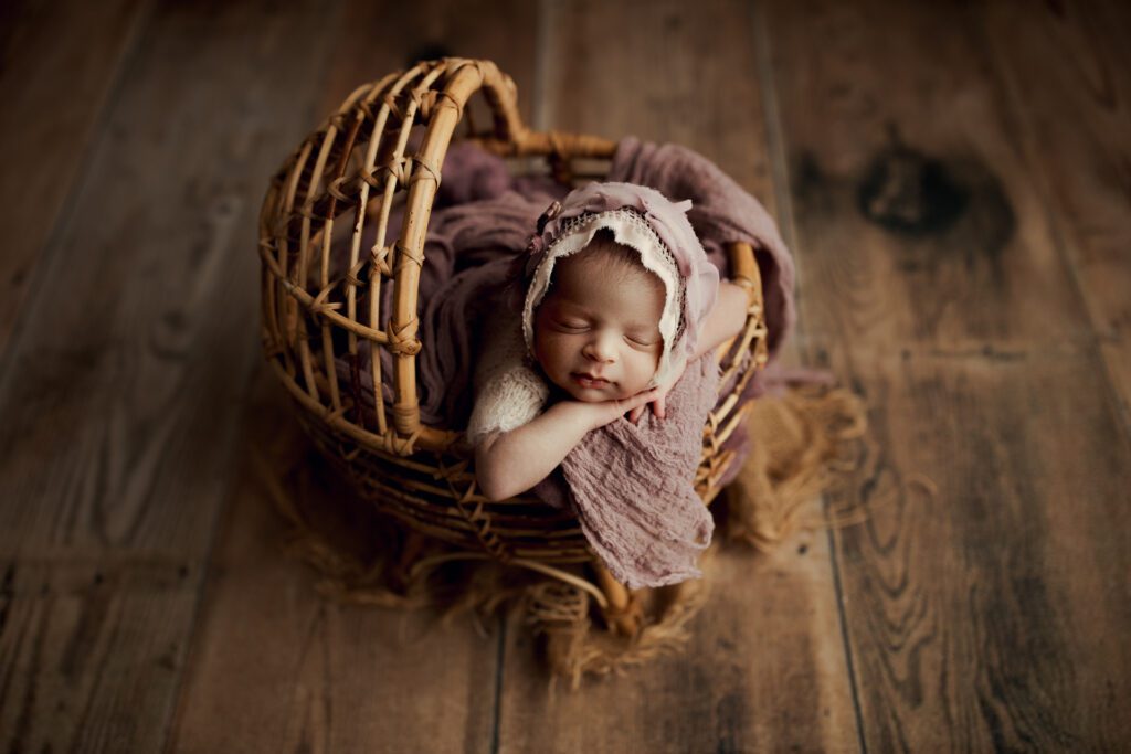 Newborn girl in wicker cradle