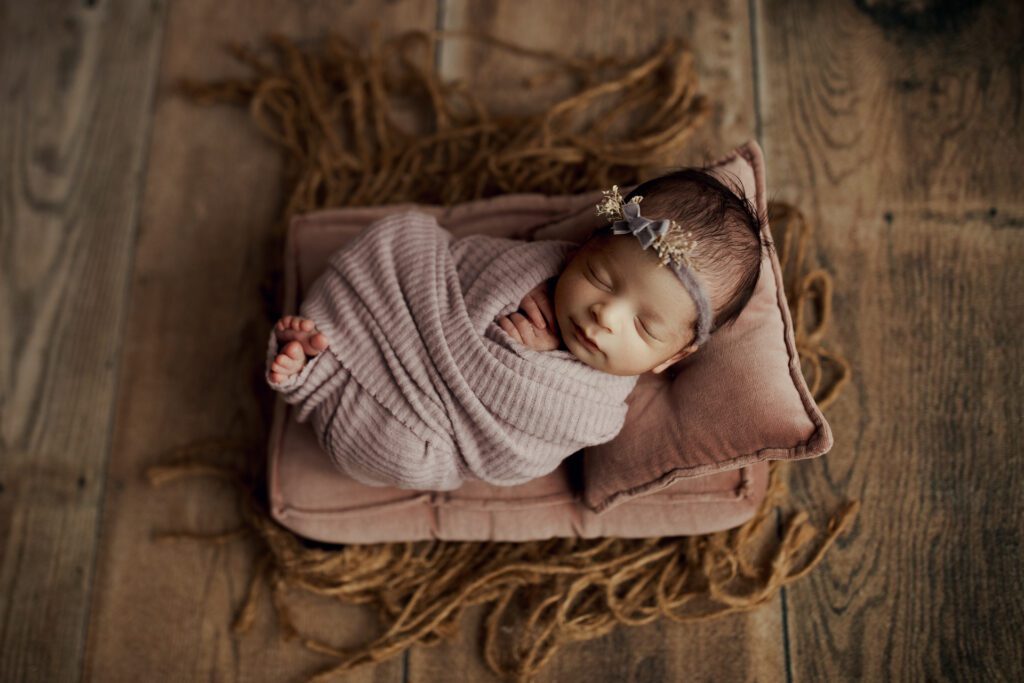 New baby girl asleep on pillow in Long Grove studio