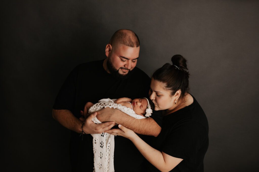Newborn and family photographer in Chicago, parents holding new baby girl