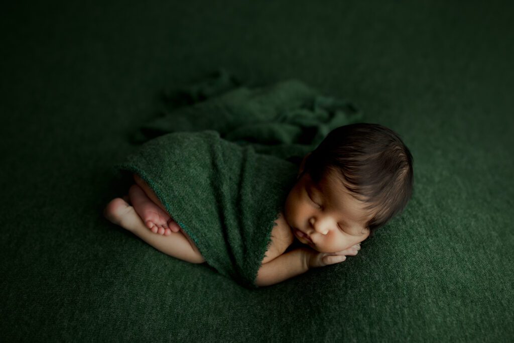 Baby boy in forest green blanket