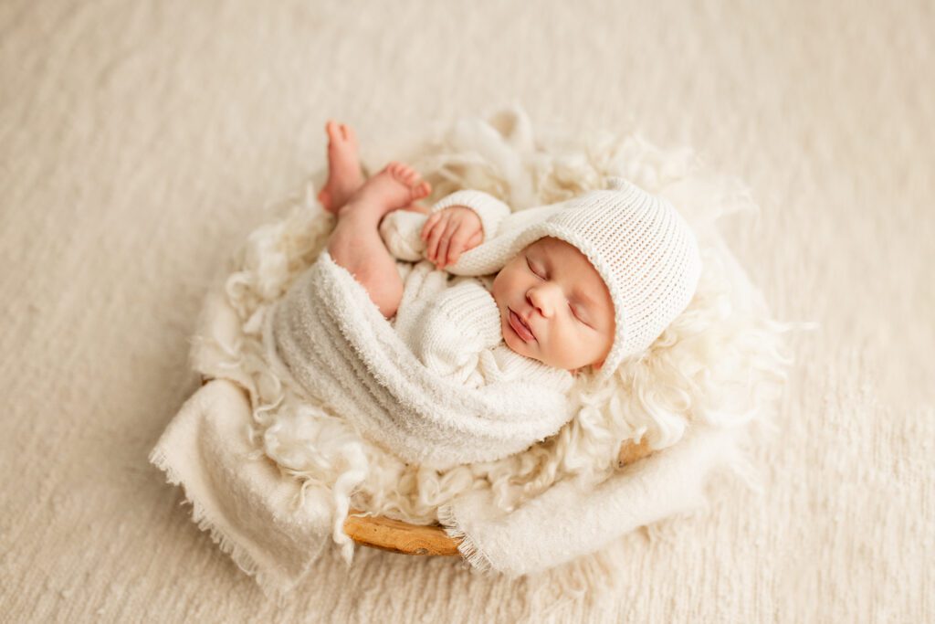 Infant boy asleep in basket in photography studio near Chicago
