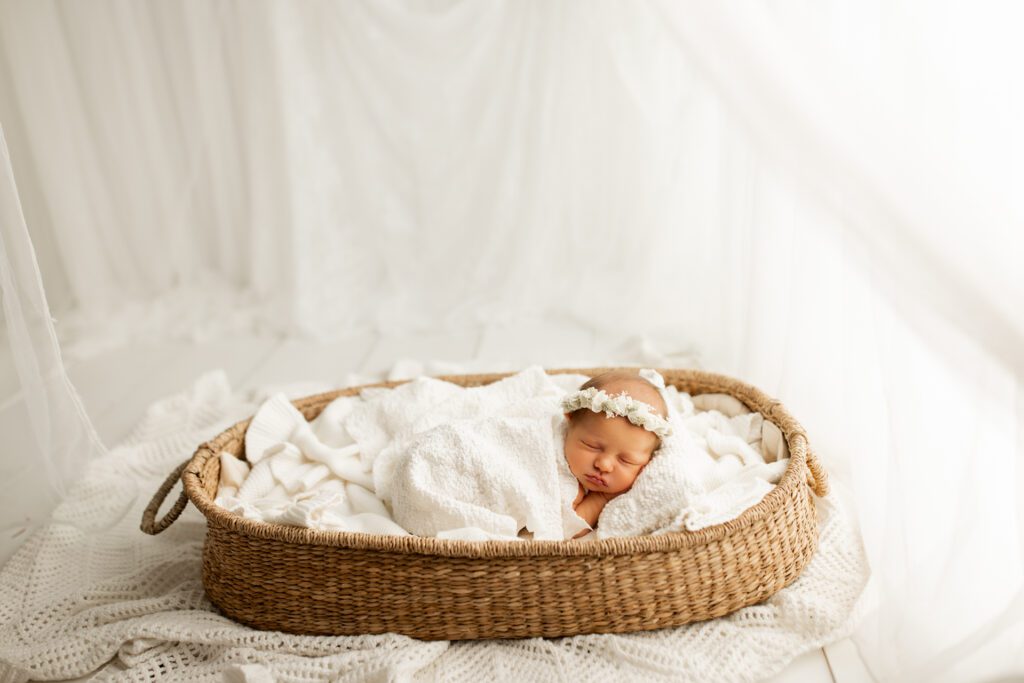 Baby girl asleep in basket in studio of newborn photographer near Lake Forest Illinois