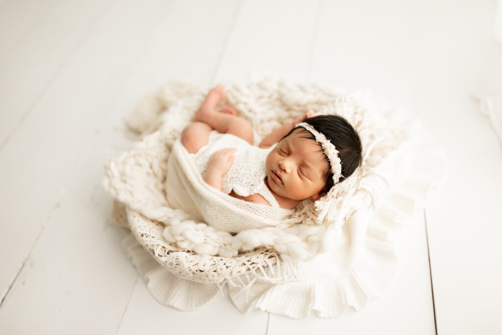 Infant girl in white sleeping in studio near Chicago Illinois