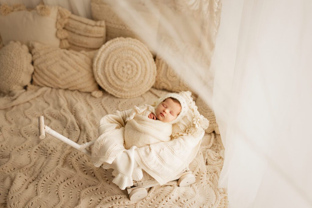 Newborn girl asleep in wooden wagon