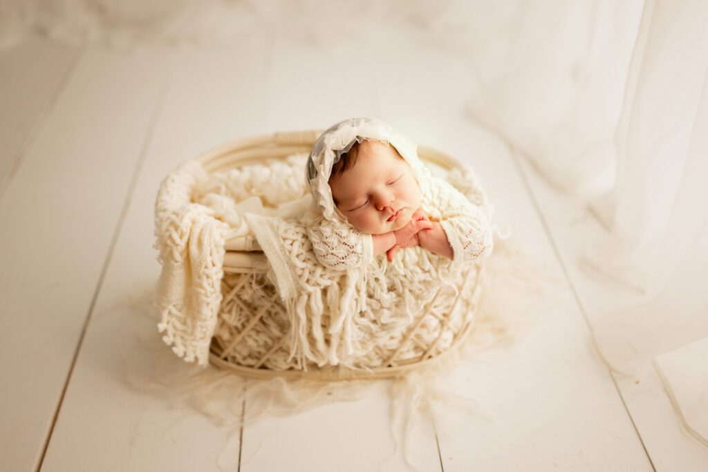 Baby girl asleep in cushioned basket