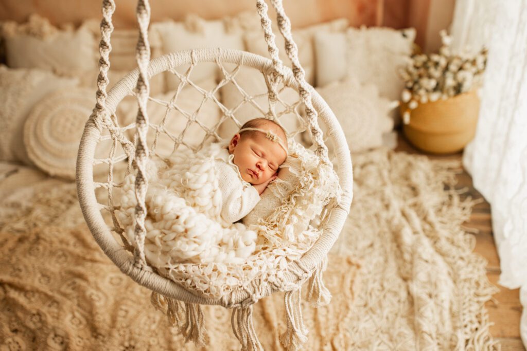 Baby girl asleep in basket swing