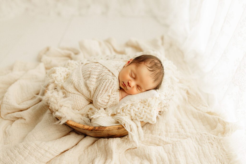 Baby boy nestled in wooden bowl prop in studio not far from his home in Winnetka, Illinois